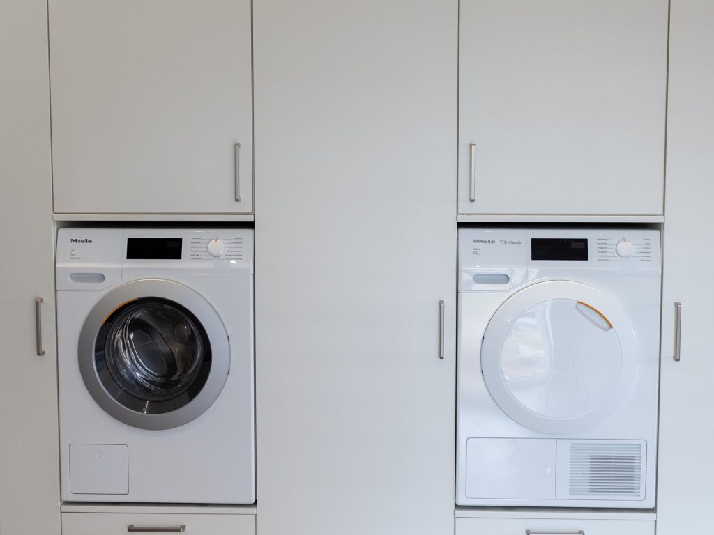 Hauswirtschaftsraum mit Waschmaschine und Trockner in erhöhter Schranknische – Schreinerei Niederreiter